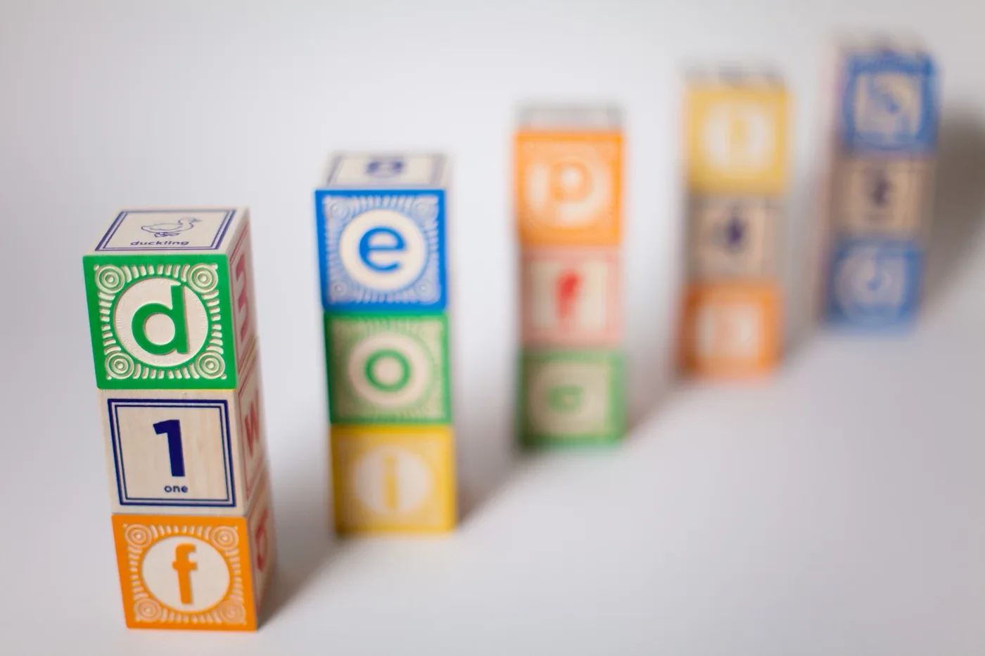 Nearest toy-block stack shows clear letter borders, while the stacks behind it become progressively blurred.